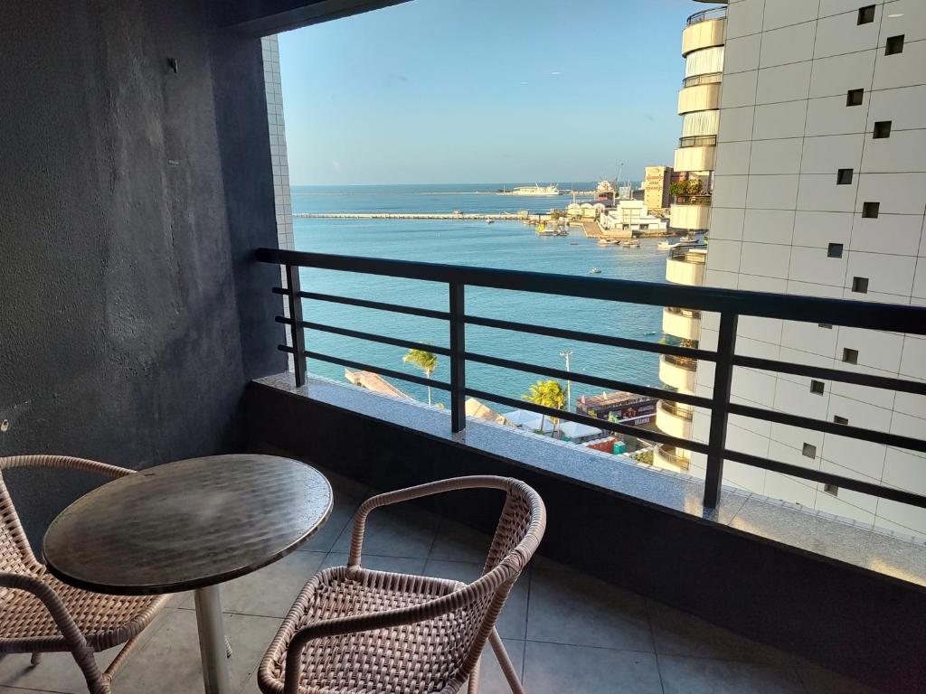 balcón con mesa, sillas y vistas al océano en Iate 1211 Luxo Beira Mar Fortaleza, en Fortaleza