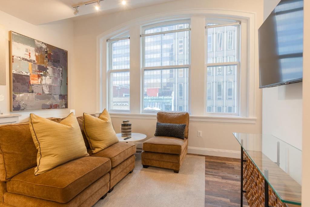 sala de estar con sofá y silla en Inner Harbor's Best Furnished Luxury Apartments apts, en Baltimore