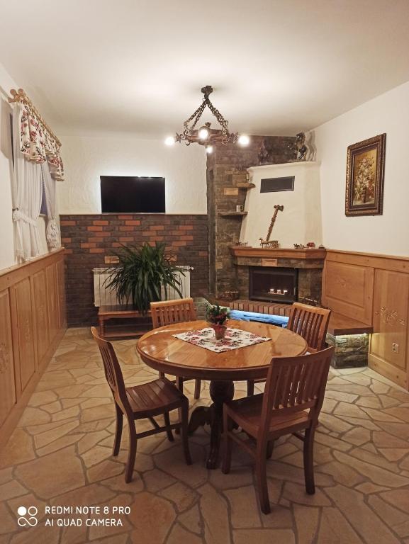 a dining room with a table and chairs and a fireplace at Willa Tatry in Bańska Niżna