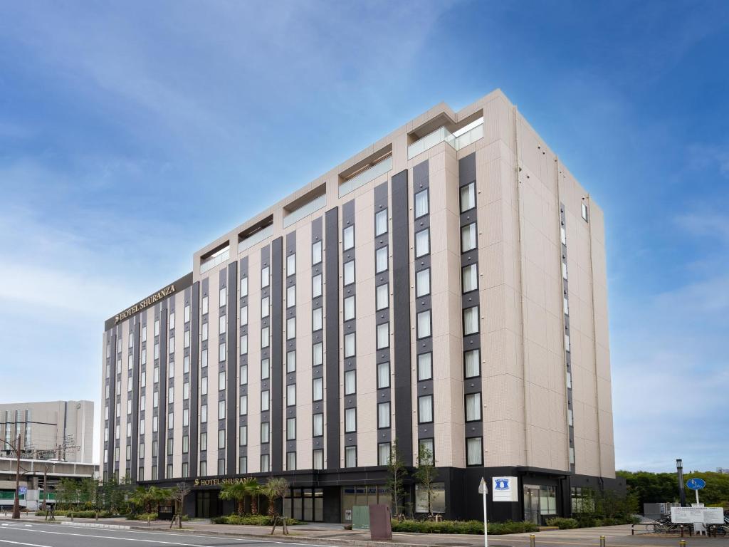 ein großes weißes Gebäude in einer Stadtstraße in der Unterkunft Hotel Shuranza MAKUHARI BAY in Chiba