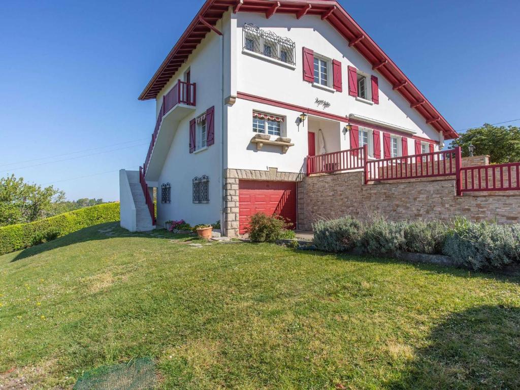 ein Haus mit einer roten Tür und einem Hof in der Unterkunft Charmant appartement à 15min de St Jean avec jardin - FR-1-4-493 in Urrugne