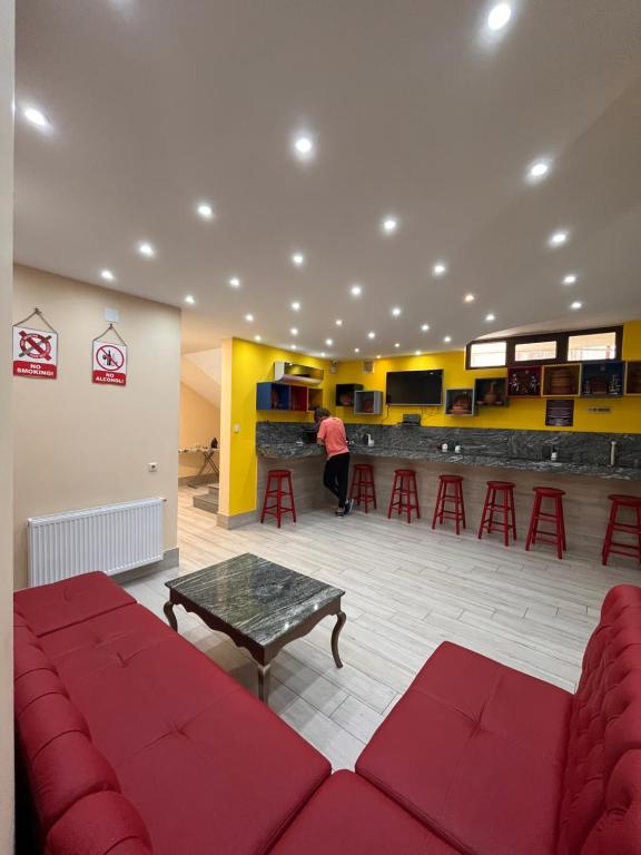 a waiting room with red couches and a bar at Hostel Jeal in Batumi