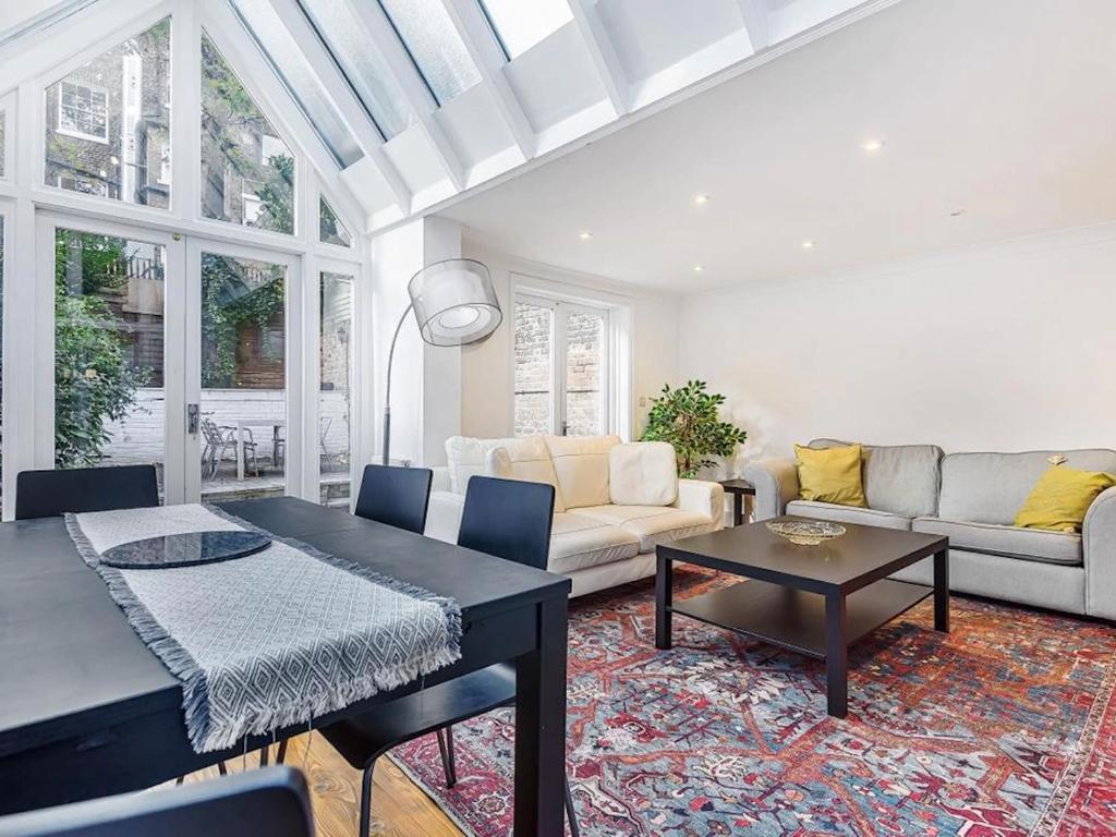 Hotel Sunny, 2bed 2bath, garden apartment near Hyde Park, a living room with a table and a couch at Sunny, 2bed 2bath, garden apartment near Hyde Park in London