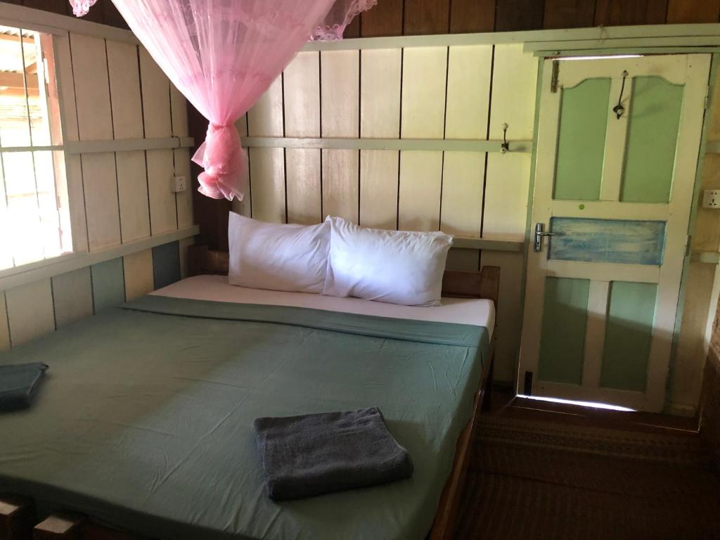 Postel nebo postele na pokoji v ubytování Retro Kampot Guesthouse