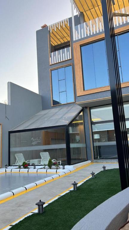 un edificio con patio y sillas frente a él en شاليه كريكت, en Abha