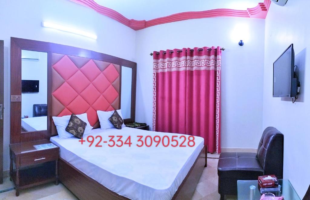 a bedroom with a large bed with a red curtain at SUBHAN PALACE Near Lasania Restaurant & Millennium Mall in Karachi