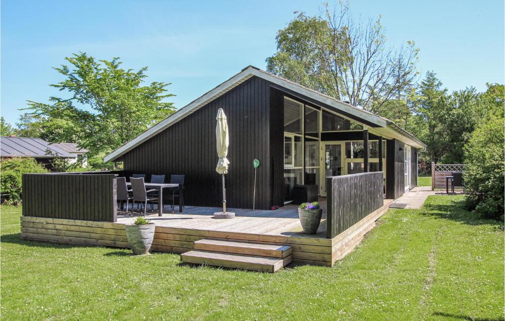 een klein zwart huis met een terras en een tafel bij 3 Bedroom Stunning Home In Sams in Onsbjerg