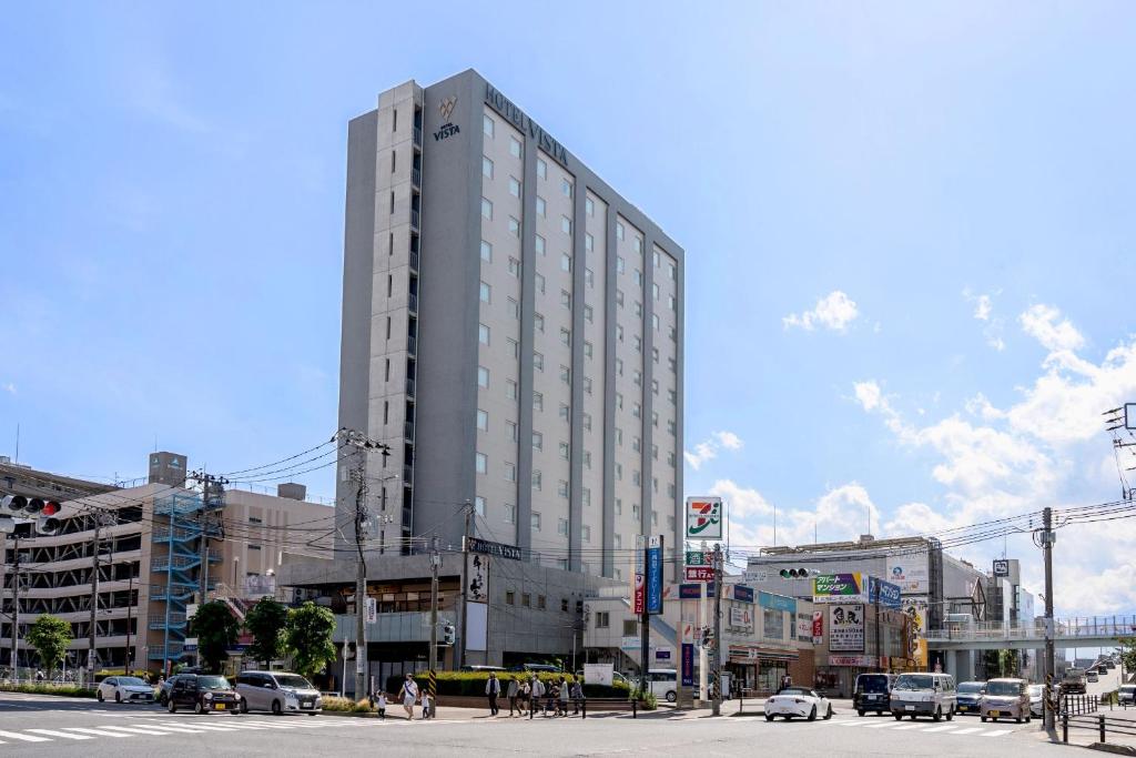 a tall building on a city street with cars at Hotel Vista Ebina in Ebina