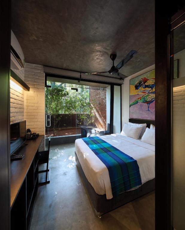 a bedroom with a bed and a desk and a window at BBQ HUB Ella in Ella