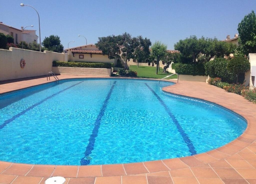 una gran piscina azul en un patio en House with pool / Garden / BBQ BEACH, en Tarragona