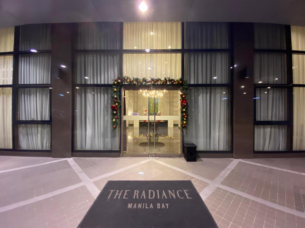 a sign in front of a building with christmas decorations at Le 10 The Radiance Manila Bay in Manila