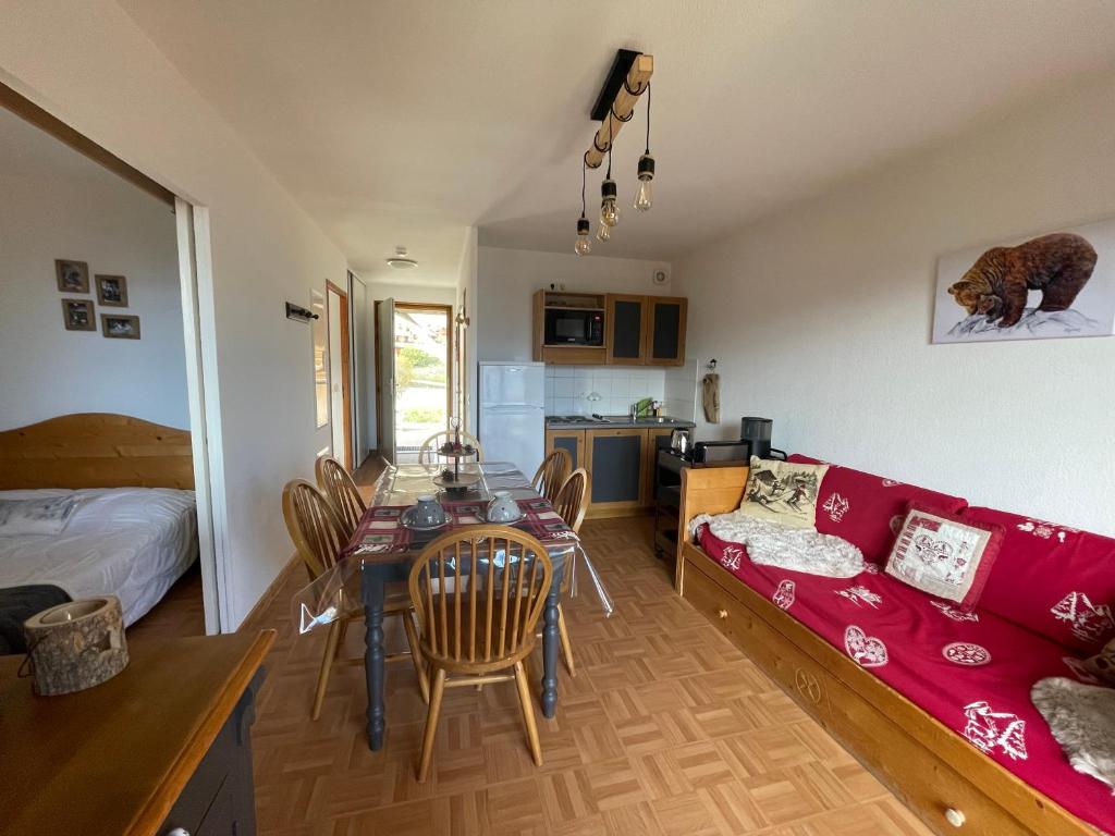 a living room with a red couch and a table at Appartement 6 places La Toussuire in La Toussuire