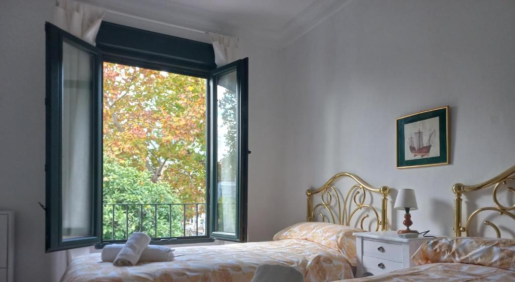 a bedroom with a bed and a large window at Rest . . . Heliópolis in Seville