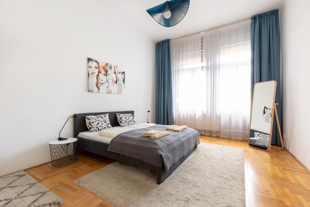 a bedroom with a bed and a large window at SZ9 Szent István Apartment in Budapest