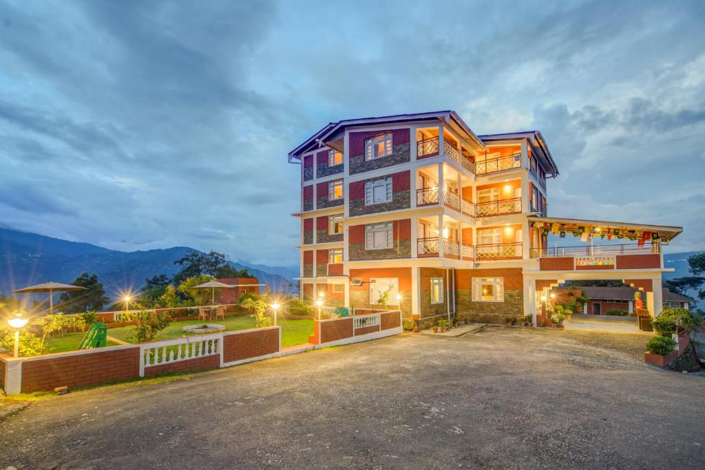 a large building with a driveway in front of it at Summit Tashi Ghang Heritage Resort in Pelling