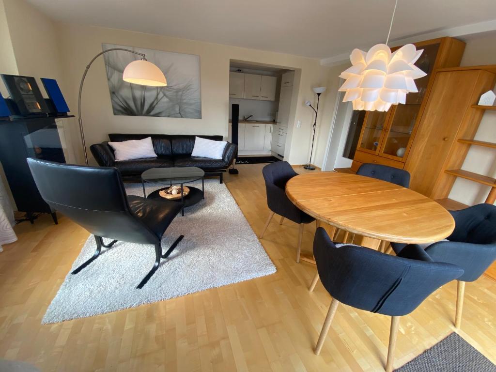 - un salon avec une table, des chaises et un canapé dans l'établissement Gästehaus Natur Wohnung Auszeit, à Vöhl