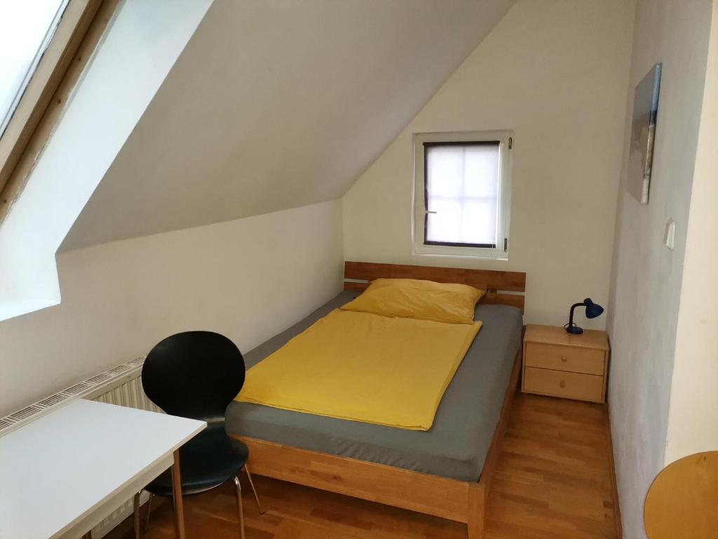 um pequeno quarto com uma cama e uma escrivaninha em Pension Prem em Kapfenberg