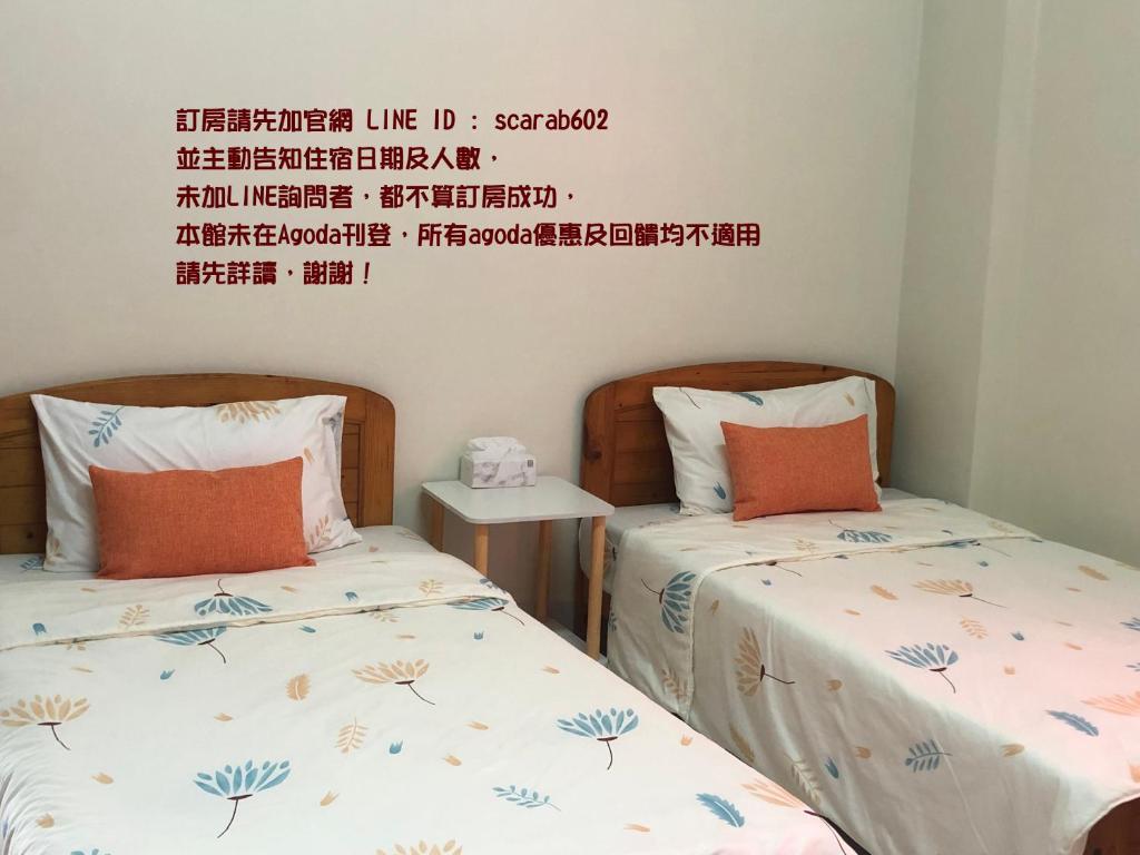 two beds in a room with writing on the wall at 聖甲虫空間 in T'u-ch'eng-tzu