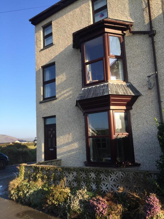 a house with a window on the side of it at Newly renovated 1st floor apartment with mountain views in Tywyn