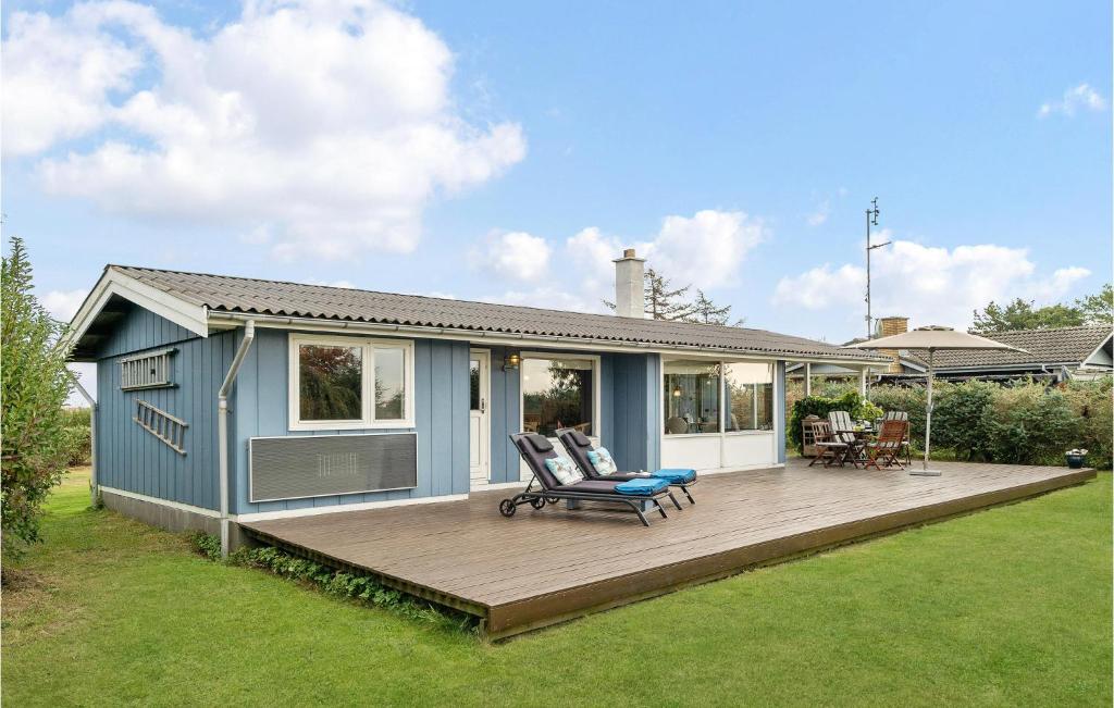 a blue house with a deck in the yard at Stunning Home In Fej With 2 Bedrooms in Kragenæs
