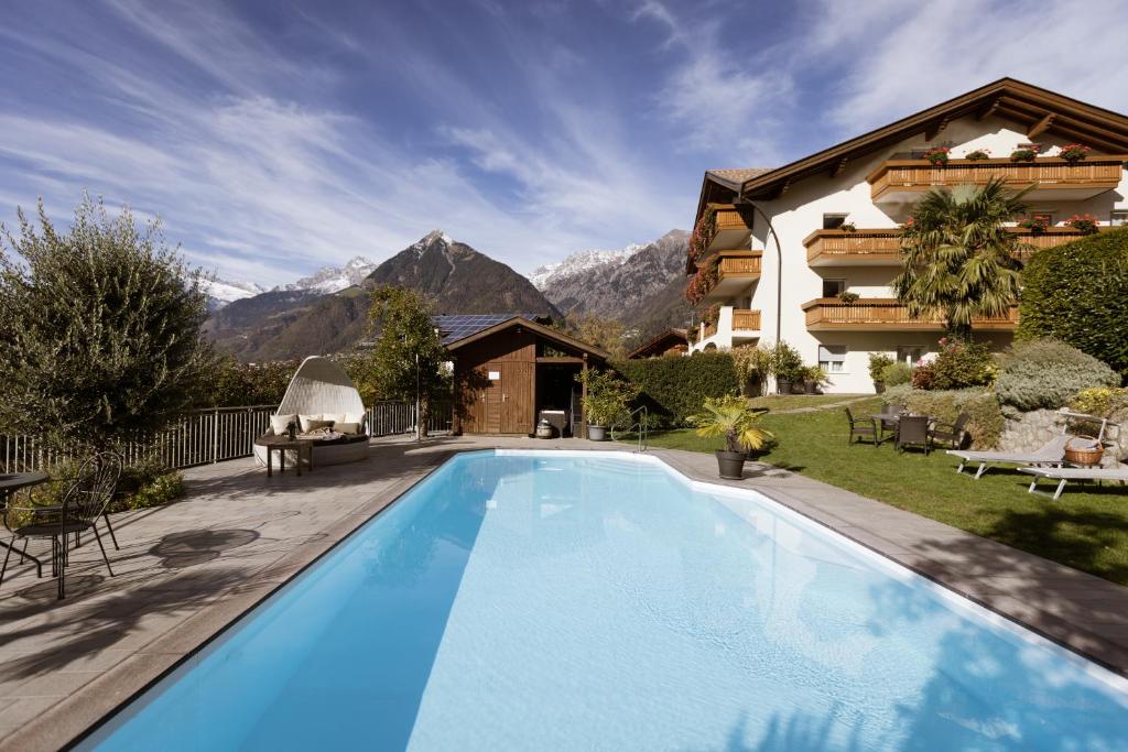 ein Schwimmbad vor einem Haus mit Bergen in der Unterkunft Residence Walchhof in Schenna