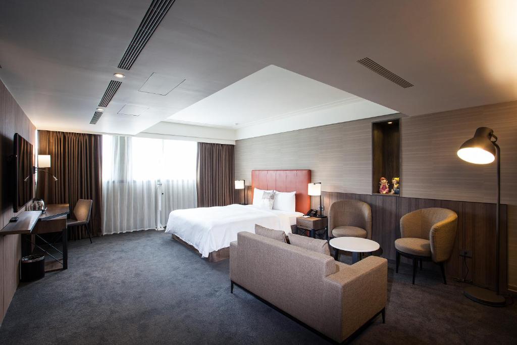 een hotelkamer met een bed en een bank en stoelen bij Citizen Hotel in Taipei