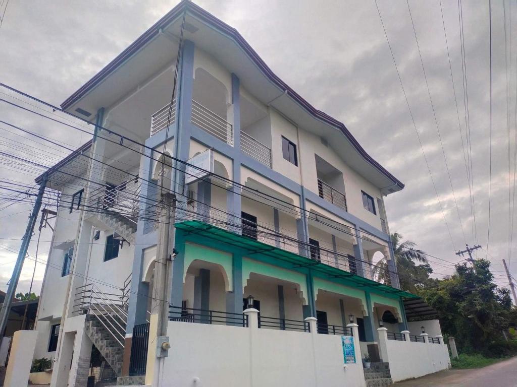 a white and blue building with a balcony at Junie Pension House in Moalboal