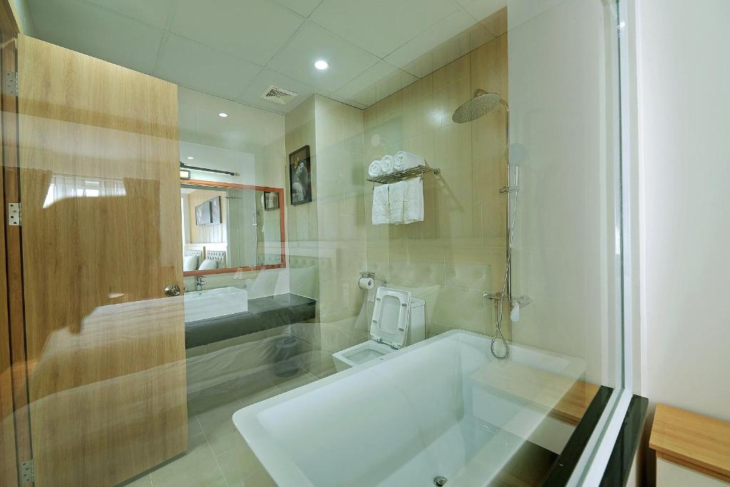 a bathroom with a bath tub and a sink at Khách sạn Xà Nu in Kon Tum