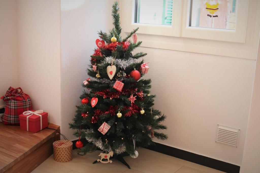 Un árbol de Navidad con adornos en una habitación en kaDevi Sanremo -centralissimo, parcheggio gratuito e bici a disposizione-, en San Remo
