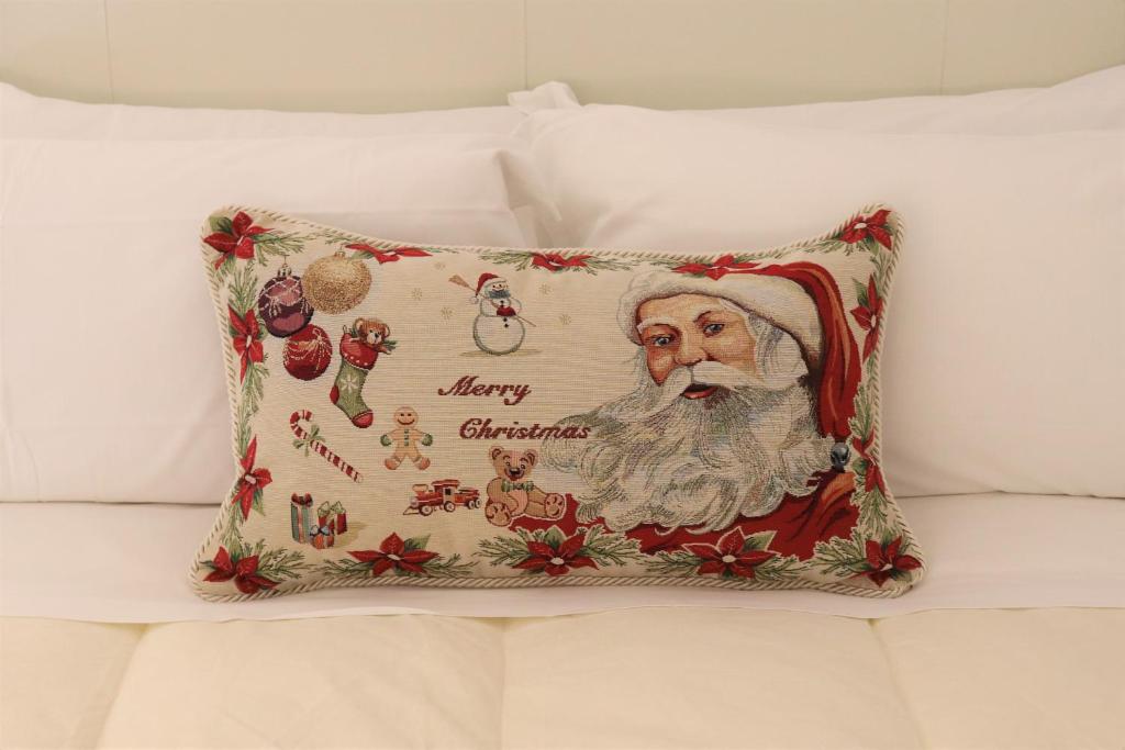 a christmas pillow with santa claus on a bed at kaDevi Sanremo -centralissimo, parcheggio gratuito e bici a disposizione- in Sanremo
