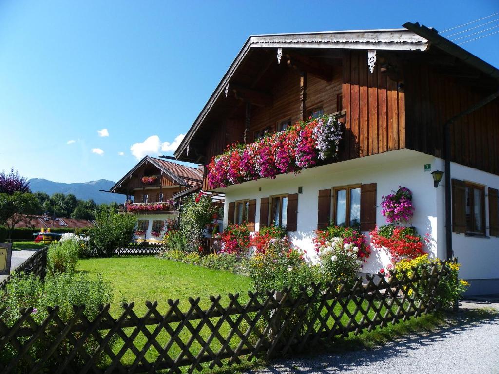 une maison avec des fleurs sur son côté dans l'établissement Ferienwohnung Geierstein, à Wackersberg