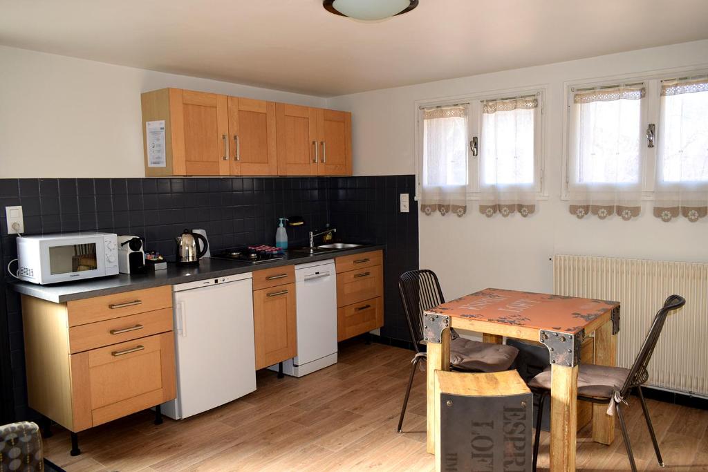 una pequeña cocina con mesa y microondas en Appartement Le 510 en Aigueblanche