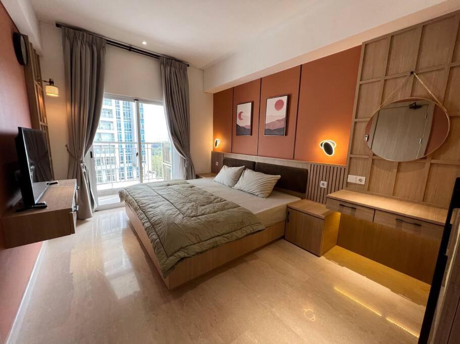 1 dormitorio con 1 cama grande y espejo en Podomoro City Deli Medan Tower Empire - Japandi Style, en Medan