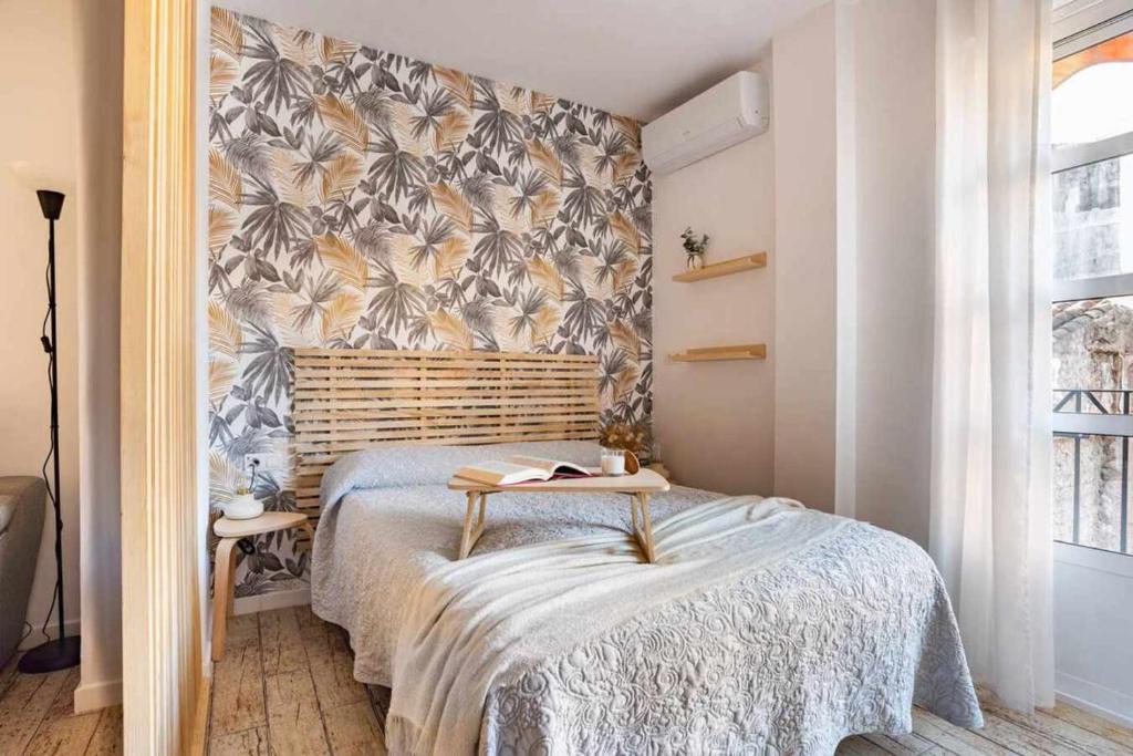 1 dormitorio con 1 cama y papel pintado con motivos florales en Apto Málaga centro histórico Parking Priv Gratuito en Málaga
