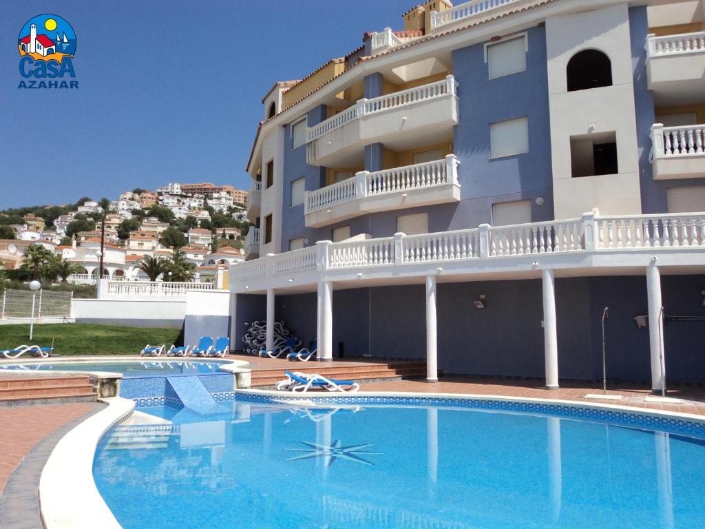 un hotel con piscina frente a un edificio en Residencial Marcomar Casa Azahar, en Alcossebre