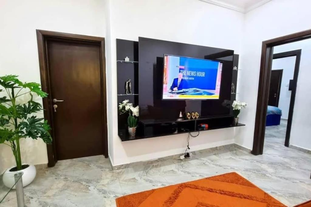 sala de estar con TV de pantalla plana en la pared en Lovely 2 bedroom in osapa london, en Lekki
