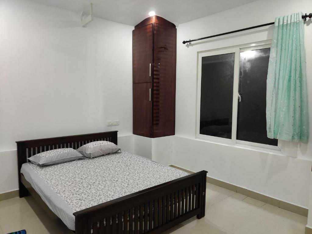 a bedroom with a bed and a window at Kochuparampil House in Idukki