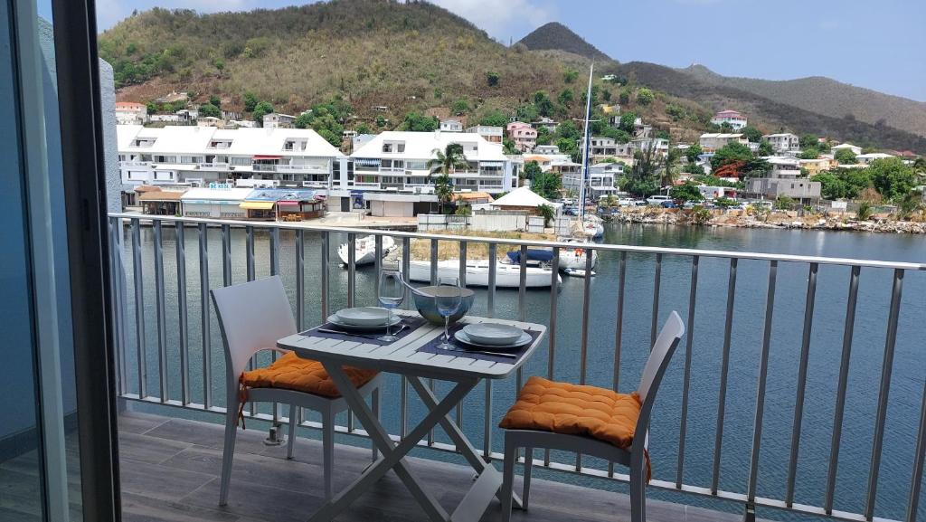 a table and chairs on a balcony with a view of a harbor at MARINA ROYALE VUE MER in Saint Martin