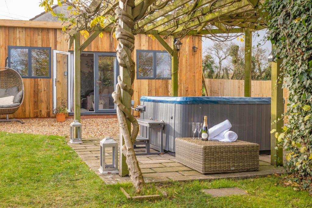 a backyard with a hot tub next to a house at Wisteria View with hottub & cabin sleeps 20 in Chippenham