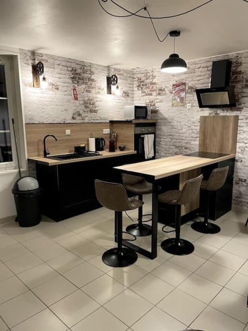 cocina con mesa, sillas y fregadero en T2 Centre ville La Licorne 2, en Pont-Audemer