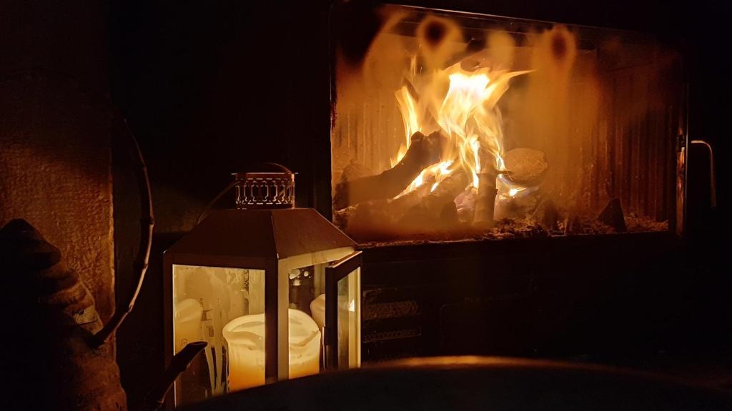 a fire in a fireplace with a lantern in front of it at Antica Corte Panego in Negrar