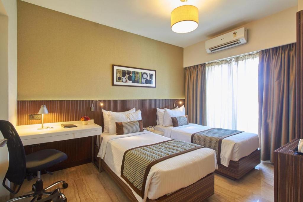 孟買的住宿－薩諾瓦波蒂科酒店，酒店客房配有两张床和一张书桌