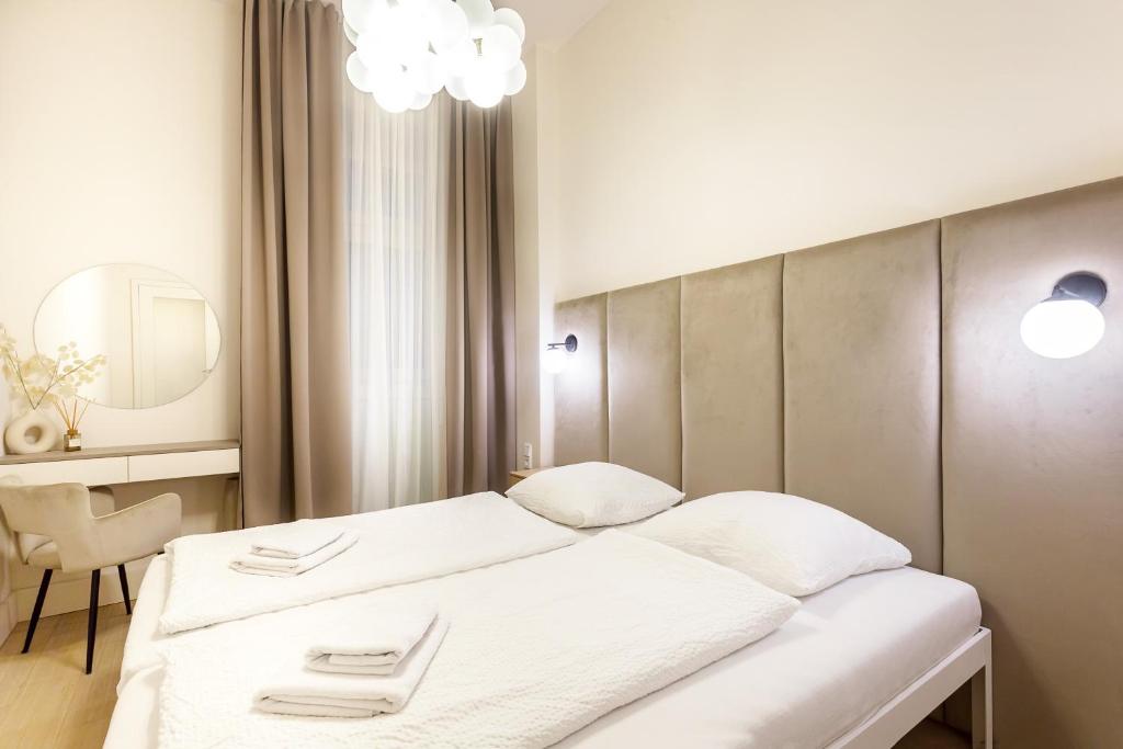 1 dormitorio con 1 cama blanca y 1 silla en Apartmá Andrea 1907 en Karlovy Vary