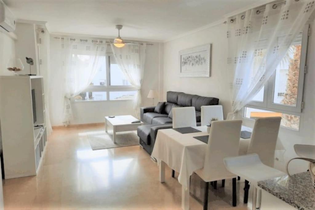 a living room with a couch and a table and chairs at Beautiful 2 Bed Apartment on Villamartin Plaza in Villacosta