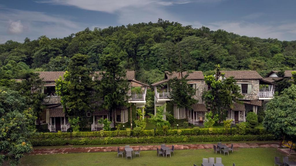 een resort in de bergen met tafels en stoelen in een tuin bij Wood castle Spa & Resort in Rāmnagar