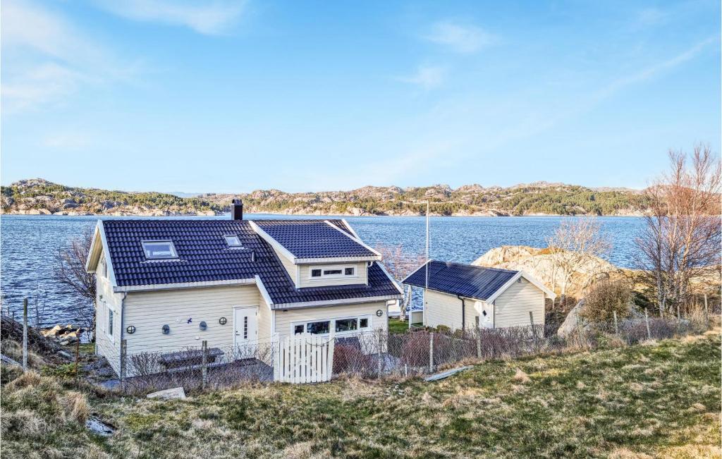 a house with solar panels on it next to a body of water at Nice Home In Egersund With Wifi in Egersund