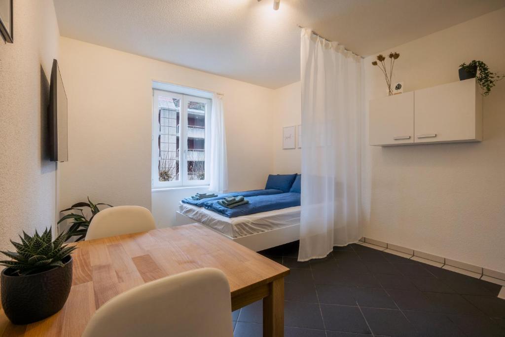 a dining room with a table and a bed in a room at Gemütliches Studio im Stadtzentrum in Biel