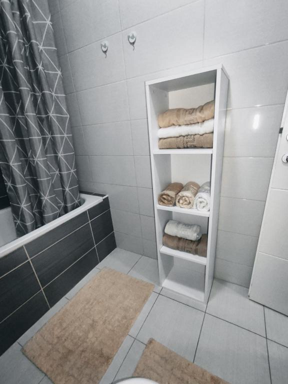 uma casa de banho com chuveiro, WC e toalhas em Nota Home em Novi Sad