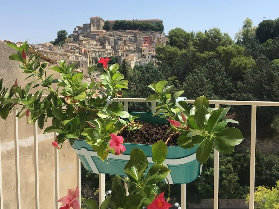 een potplant bovenop een balkon met een stad bij Dimora d'Artista in Ragusa