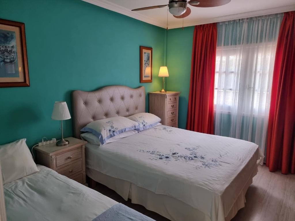 - une chambre avec 2 lits et des murs bleus dans l'établissement The Palms Golf del Sur, à San Miguel de Abona